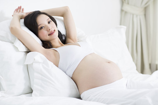 Pregnant woman lying in bed