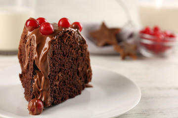 Piece of chocolate cake with snowball tree berries on a table