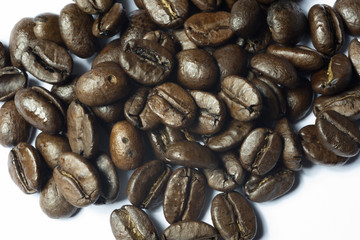 close up of roasted coffee beans on white background