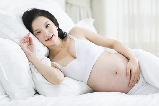 Pregnant woman lying in bed