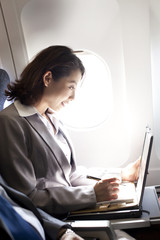 Obraz na płótnie Canvas Businesswoman working on the plane