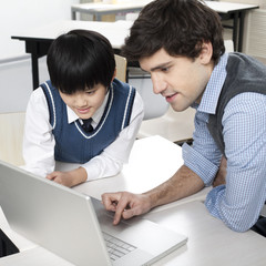 Student and teacher using computer together