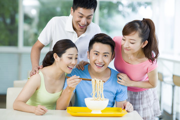 Young adults having noodles in restaurant