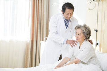 Obraz premium Doctor using stethoscope on patient in hospital