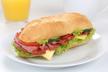 Sandwich Baguette belegt mit Salami zum Frühstück mit Orangens