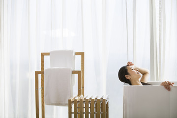 Young woman relaxing in bathtub