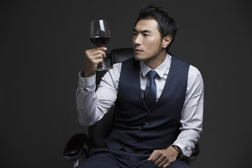Confident businessman enjoying red wine