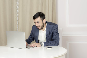 Portrait of a man with a laptop. A man sits at a Desk and working. 