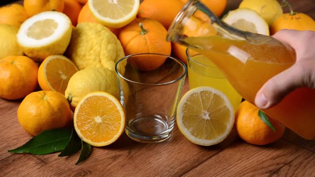 versare il succo di arancia nel bicchiere di vetro