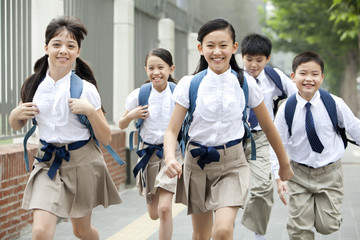 Lively schoolchildren in uniform on the way to school