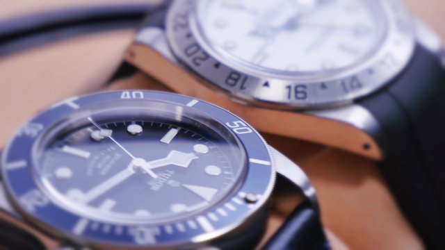 Extreme close-up shot of two luxury wristwatches spin in an automated watch winder.