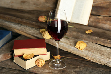 Beautiful composition with glass of wine with old books on table close up
