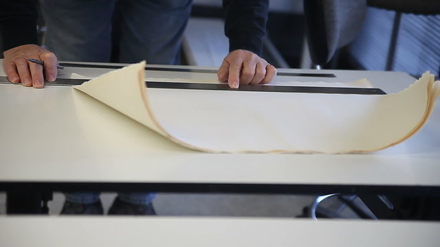 Front view of man using a straight edge on paper