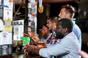 Young men drinking beer in pub