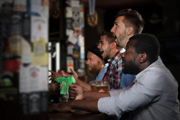 Young men drinking beer in pub