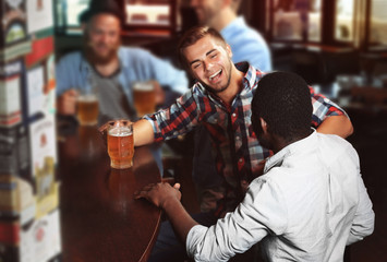 Young men drinking beer in pub