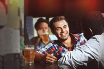 Young men drinking beer in pub