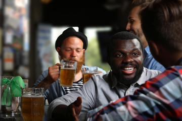 Young men drinking beer in pub