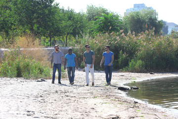 Young men walking along the riverside