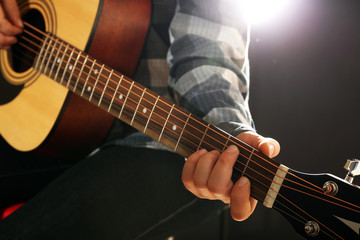 Obraz na płótnie Canvas Musician plays guitar on black background, close up