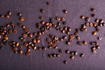 Roasted coffee beans on grey textile background
