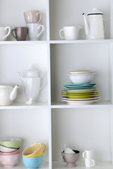 Fototapeta na wymiar Different clean dishes on wooden shelves