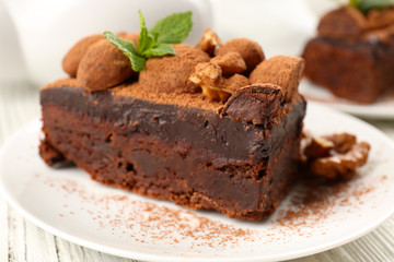 Piece of chocolate cake with walnut and mint on the table, close-up
