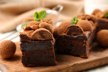 A piece of chocolate cake with walnut and mint on the table, close-up