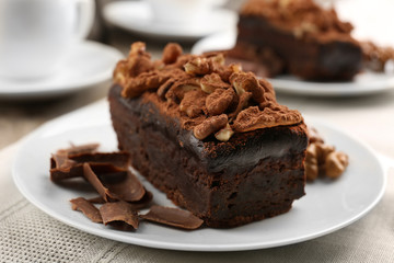 A piece of chocolate cake with walnut on the table, close-up