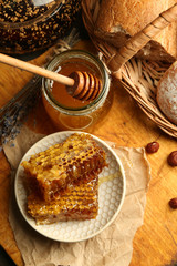 Honeycombs on plate, hot buns on wooden background