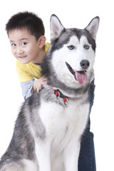 Cute little boy playing with a Husky dog