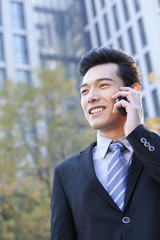 Businessman outside buildings on his mobile phone