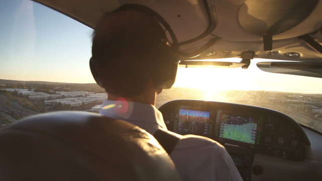 Pilot Operates Private Plane At Sunset View. Close Up Shot Of Airplane Cabin.