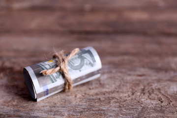 Roll of Euro banknotes on wooden background