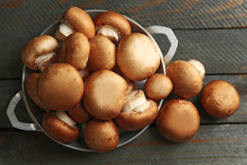 Mushrooms in bowl on wooden surface
