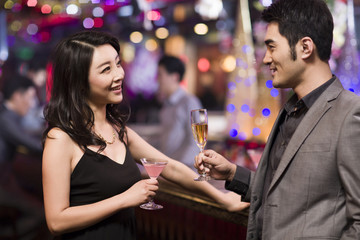 Young woman talking with young man in bar