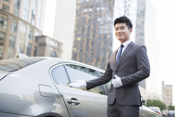Chauffeur greeting next to the car © Blue Jean Images