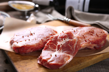Marbled beef steak with bottle of wine and spices on wooden background