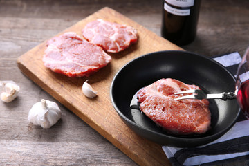 Marbled beef steak and wine bottle on wooden background
