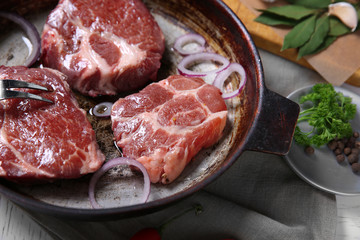 Marbled beef steak on pan and spices on color wooden background