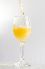 Beer pouring from above into wine glass