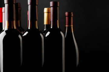 Wine bottles on black background © Africa Studio