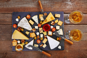 Cheese for tasting on wooden background, top view