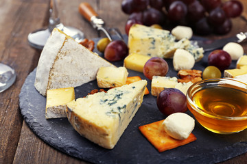 Cheese for tasting on wooden table, closeup