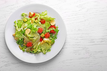 Tasty salmon salad on light wooden background