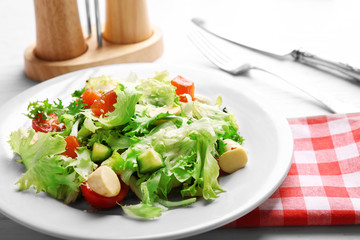 Tasty salmon salad on light wooden background