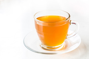 Hot aromatic honey tea in transparent cup and saucer