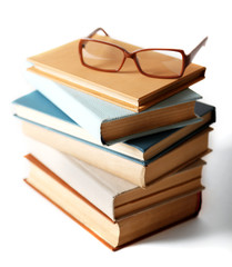 Pile of books and eyeglasses on it isolated on white background
