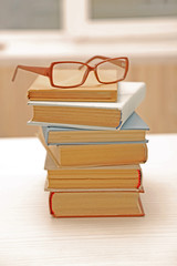 Pile of books and eyeglasses on it, close up