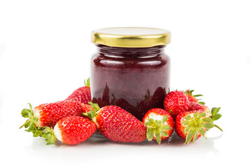 Organic strawberry jam in transparent glass jar with fresh strawberries